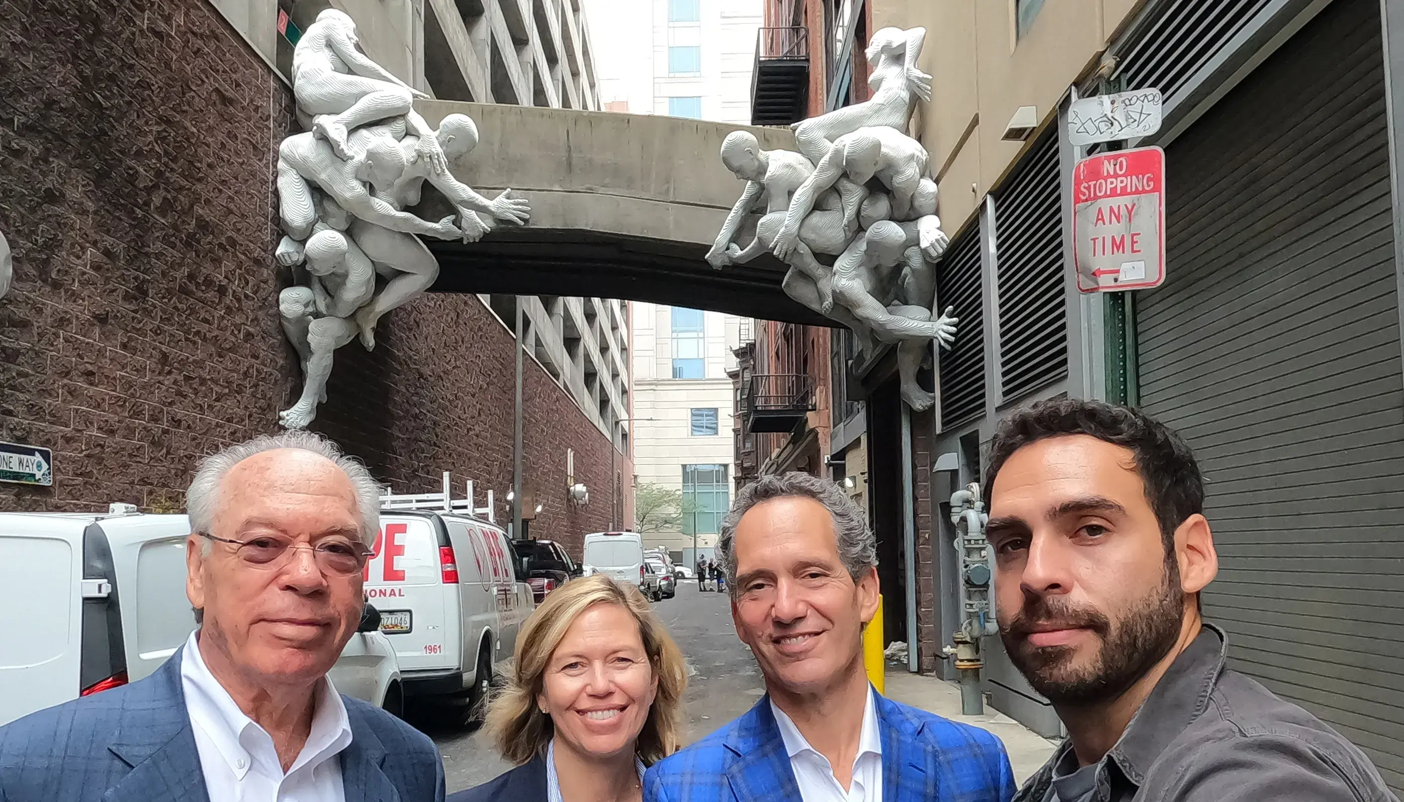 People smiling in front of Contrafuerte sculpture